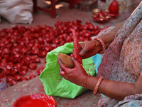 A woman vendor colors earthen lamps 'Diyas' at her roadside shop ahead of the Diwali Festival in Jaipur, Rajasthan, India, on October 23, 20...