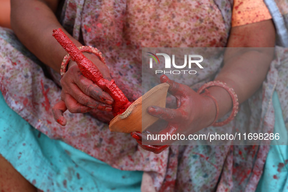 A woman vendor colors earthen lamps 'Diyas' at her roadside shop ahead of the Diwali Festival in Jaipur, Rajasthan, India, on October 23, 20...