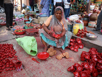 A woman vendor colors earthen lamps 'Diyas' at her roadside shop ahead of the Diwali Festival in Jaipur, Rajasthan, India, on October 23, 20...