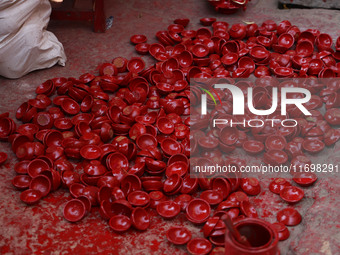 A woman vendor colors earthen lamps 'Diyas' at her roadside shop ahead of the Diwali Festival in Jaipur, Rajasthan, India, on October 23, 20...