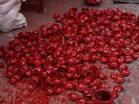 A woman vendor colors earthen lamps 'Diyas' at her roadside shop ahead of the Diwali Festival in Jaipur, Rajasthan, India, on October 23, 20...