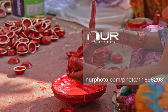 A woman vendor colors earthen lamps 'Diyas' at her roadside shop ahead of the Diwali Festival in Jaipur, Rajasthan, India, on October 23, 20...