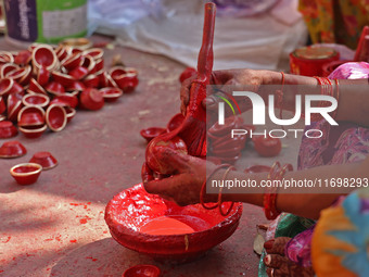 A woman vendor colors earthen lamps 'Diyas' at her roadside shop ahead of the Diwali Festival in Jaipur, Rajasthan, India, on October 23, 20...