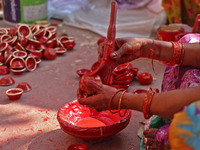 A woman vendor colors earthen lamps 'Diyas' at her roadside shop ahead of the Diwali Festival in Jaipur, Rajasthan, India, on October 23, 20...