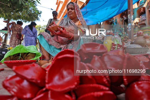 A woman vendor colors earthen lamps 'Diyas' at her roadside shop ahead of the Diwali Festival in Jaipur, Rajasthan, India, on October 23, 20...