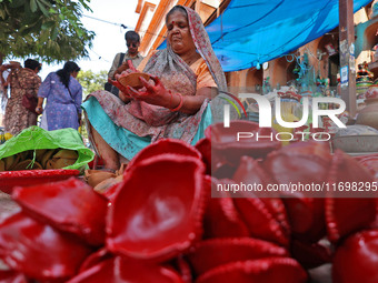 A woman vendor colors earthen lamps 'Diyas' at her roadside shop ahead of the Diwali Festival in Jaipur, Rajasthan, India, on October 23, 20...