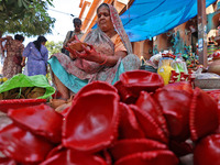 A woman vendor colors earthen lamps 'Diyas' at her roadside shop ahead of the Diwali Festival in Jaipur, Rajasthan, India, on October 23, 20...