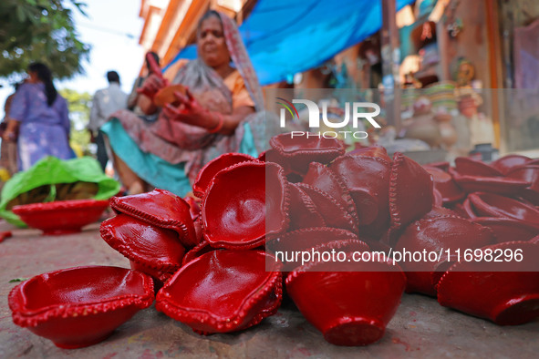 A woman vendor colors earthen lamps 'Diyas' at her roadside shop ahead of the Diwali Festival in Jaipur, Rajasthan, India, on October 23, 20...