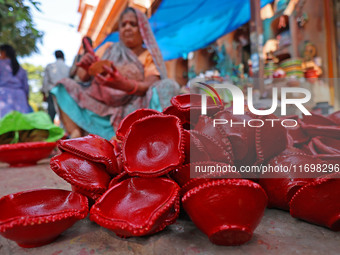 A woman vendor colors earthen lamps 'Diyas' at her roadside shop ahead of the Diwali Festival in Jaipur, Rajasthan, India, on October 23, 20...