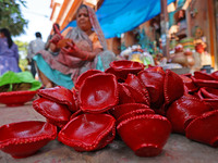 A woman vendor colors earthen lamps 'Diyas' at her roadside shop ahead of the Diwali Festival in Jaipur, Rajasthan, India, on October 23, 20...