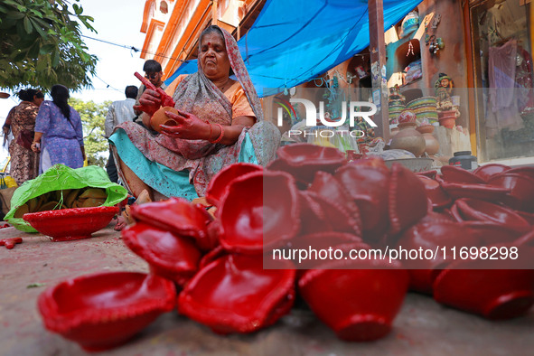 A woman vendor colors earthen lamps 'Diyas' at her roadside shop ahead of the Diwali Festival in Jaipur, Rajasthan, India, on October 23, 20...