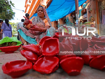 A woman vendor colors earthen lamps 'Diyas' at her roadside shop ahead of the Diwali Festival in Jaipur, Rajasthan, India, on October 23, 20...