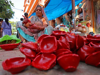 A woman vendor colors earthen lamps 'Diyas' at her roadside shop ahead of the Diwali Festival in Jaipur, Rajasthan, India, on October 23, 20...