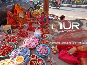 A woman vendor colors earthen lamps 'Diyas' at her roadside shop ahead of the Diwali Festival in Jaipur, Rajasthan, India, on October 23, 20...