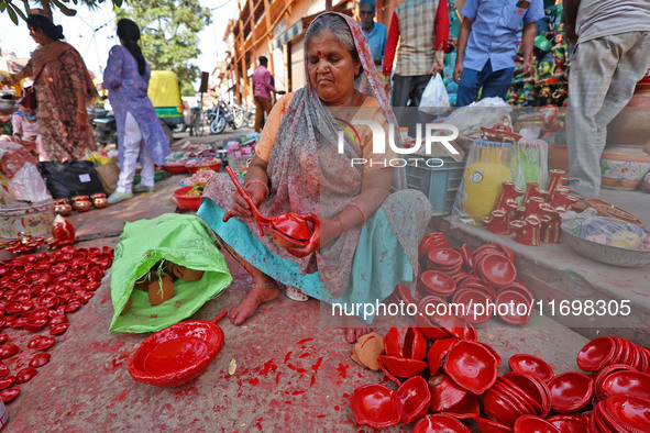 A woman vendor colors earthen lamps 'Diyas' at her roadside shop ahead of the Diwali Festival in Jaipur, Rajasthan, India, on October 23, 20...