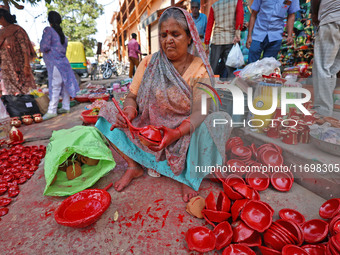 A woman vendor colors earthen lamps 'Diyas' at her roadside shop ahead of the Diwali Festival in Jaipur, Rajasthan, India, on October 23, 20...