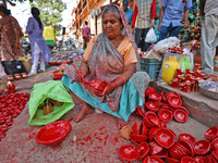 A woman vendor colors earthen lamps 'Diyas' at her roadside shop ahead of the Diwali Festival in Jaipur, Rajasthan, India, on October 23, 20...