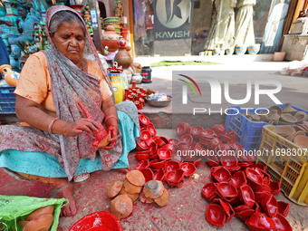 A woman vendor colors earthen lamps 'Diyas' at her roadside shop ahead of the Diwali Festival in Jaipur, Rajasthan, India, on October 23, 20...