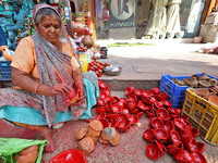 A woman vendor colors earthen lamps 'Diyas' at her roadside shop ahead of the Diwali Festival in Jaipur, Rajasthan, India, on October 23, 20...