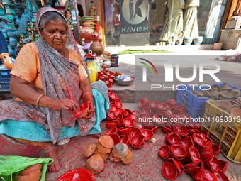 A woman vendor colors earthen lamps 'Diyas' at her roadside shop ahead of the Diwali Festival in Jaipur, Rajasthan, India, on October 23, 20...