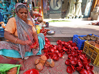 A woman vendor colors earthen lamps 'Diyas' at her roadside shop ahead of the Diwali Festival in Jaipur, Rajasthan, India, on October 23, 20...