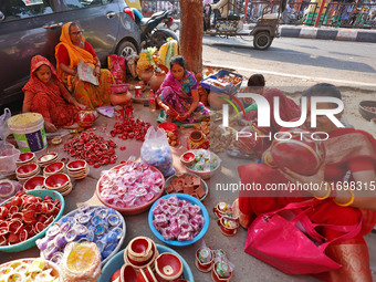 A woman vendor colors earthen lamps 'Diyas' at her roadside shop ahead of the Diwali Festival in Jaipur, Rajasthan, India, on October 23, 20...