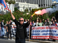 A protester holds a flare as kindergarten and primary school teachers demonstrate in front of the Greek Parliament demanding salary increase...