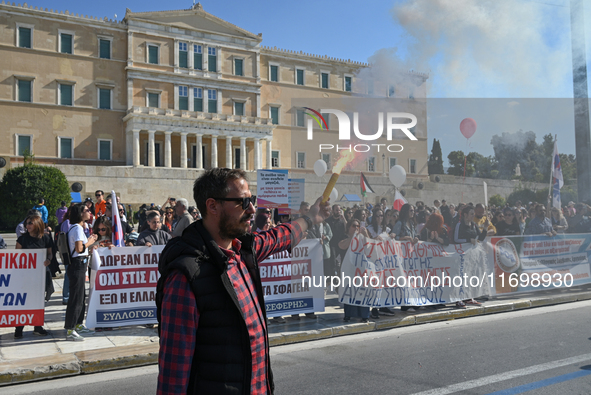 A protester holds a flare as kindergarten and primary school teachers demonstrate in front of the Greek Parliament demanding salary increase...