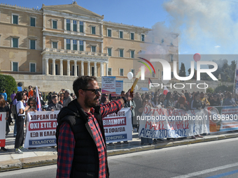 A protester holds a flare as kindergarten and primary school teachers demonstrate in front of the Greek Parliament demanding salary increase...