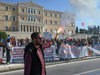 A protester holds a flare as kindergarten and primary school teachers demonstrate in front of the Greek Parliament demanding salary increase...