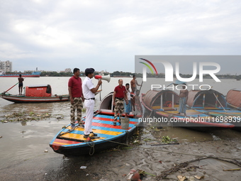 A member of the Kolkata river traffic police uses a megaphone to appeal to people to move to a safer place ahead of Cyclone Dana during patr...