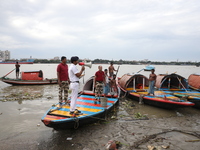 A member of the Kolkata river traffic police uses a megaphone to appeal to people to move to a safer place ahead of Cyclone Dana during patr...