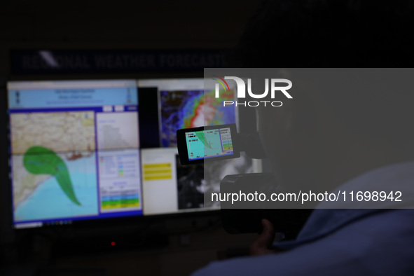 The TV camera's viewfinder screen shows the position of Cyclone Dana inside the Regional Meteorological Centre Kolkata (IMD) office in Kolka...