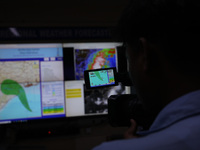 The TV camera's viewfinder screen shows the position of Cyclone Dana inside the Regional Meteorological Centre Kolkata (IMD) office in Kolka...