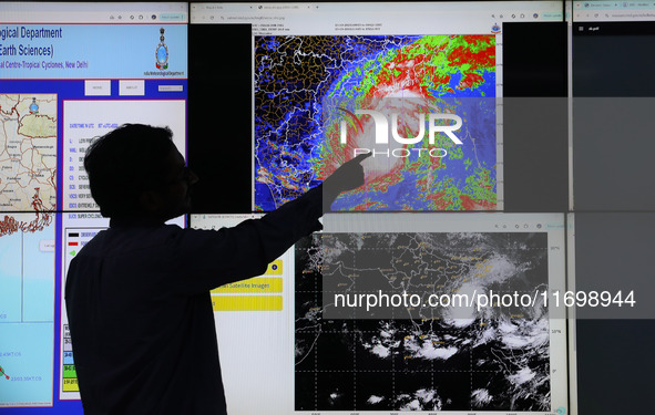 A scientist at the India Meteorological Department Earth System Science Organisation points to a section of the screen showing the position...