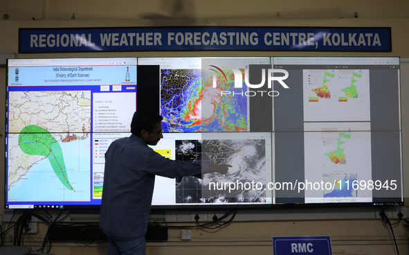 A scientist at the India Meteorological Department Earth System Science Organisation points to a section of the screen showing the position...