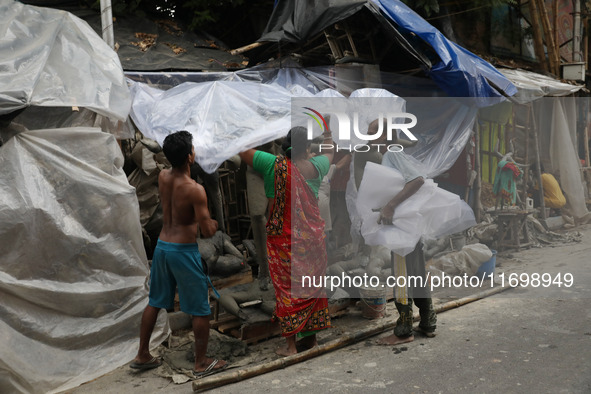 Workers cover idols of the Hindu goddess Kali with a plastic sheet ahead of Cyclone Dana in Kolkata, India, on October 23, 2024. The Regiona...