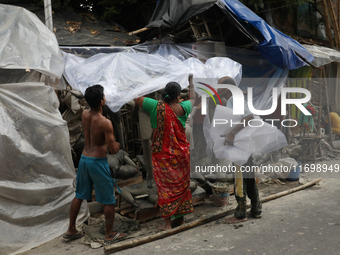 Workers cover idols of the Hindu goddess Kali with a plastic sheet ahead of Cyclone Dana in Kolkata, India, on October 23, 2024. The Regiona...