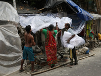 Workers cover idols of the Hindu goddess Kali with a plastic sheet ahead of Cyclone Dana in Kolkata, India, on October 23, 2024. The Regiona...