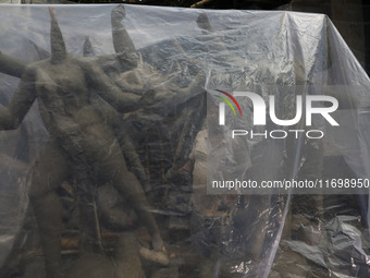 A worker covers idols of the Hindu goddess Kali with a plastic sheet ahead of Cyclone Dana in Kolkata, India, on October 23, 2024. The Regio...