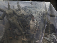 A worker covers idols of the Hindu goddess Kali with a plastic sheet ahead of Cyclone Dana in Kolkata, India, on October 23, 2024. The Regio...