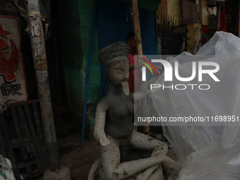 A worker covers an idol of the Hindu goddess Kali with a plastic sheet ahead of Cyclone Dana in Kolkata, India, on October 23, 2024. The Reg...