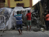 Workers cover idols of the Hindu goddess Kali with a plastic sheet ahead of Cyclone Dana in Kolkata, India, on October 23, 2024. The Regiona...