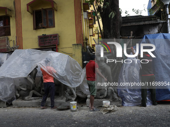 Workers cover idols of the Hindu goddess Kali with a plastic sheet ahead of Cyclone Dana in Kolkata, India, on October 23, 2024. The Regiona...