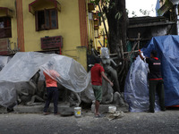 Workers cover idols of the Hindu goddess Kali with a plastic sheet ahead of Cyclone Dana in Kolkata, India, on October 23, 2024. The Regiona...