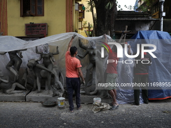 Workers cover idols of the Hindu goddess Kali with a plastic sheet ahead of Cyclone Dana in Kolkata, India, on October 23, 2024. The Regiona...