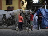 Workers cover idols of the Hindu goddess Kali with a plastic sheet ahead of Cyclone Dana in Kolkata, India, on October 23, 2024. The Regiona...