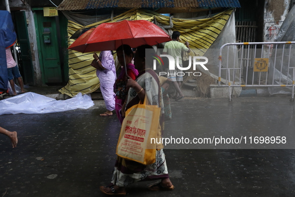 A woman with an umbrella walks on a road during rains caused by Cyclone Dana in Kolkata, India, on October 23, 2024. The Regional Meteorolog...