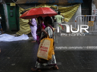 A woman with an umbrella walks on a road during rains caused by Cyclone Dana in Kolkata, India, on October 23, 2024. The Regional Meteorolog...