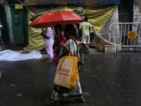 A woman with an umbrella walks on a road during rains caused by Cyclone Dana in Kolkata, India, on October 23, 2024. The Regional Meteorolog...